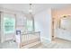 Cozy bedroom features a crib, windows with natural light, and an en suite bathroom at 112 Filigree Way, Durham, NC 27713