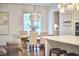 Dining room with hardwood floors, modern chandelier, and a wooden table with upholstered chairs at 112 Filigree Way, Durham, NC 27713