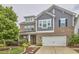 Charming two-story brick and siding home featuring a two-car garage, a lush green lawn, and mature trees at 112 Filigree Way, Durham, NC 27713