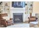 Living room with fireplace, built in shelving, leather chairs and a comfortable sofa at 112 Filigree Way, Durham, NC 27713