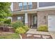 Inviting front entrance with a brick facade, manicured landscaping, and a glimpse of the glass paneled front door at 112 Filigree Way, Durham, NC 27713