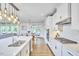 Open-concept kitchen with an island, white cabinetry, stainless steel appliances, and hardwood floors at 112 Filigree Way, Durham, NC 27713