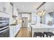 Modern kitchen boasting white cabinets, stainless appliances, an island, and attractive pendant lights at 112 Filigree Way, Durham, NC 27713