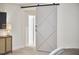 Bright bedroom features a tufted bed, side tables, and modern sliding barn door at 112 Filigree Way, Durham, NC 27713