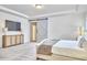 Bright bedroom features a tufted bed, tray ceilings, and modern sliding barn door at 112 Filigree Way, Durham, NC 27713