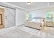 Bright bedroom features a tufted bed, tray ceilings, and modern sliding barn door at 112 Filigree Way, Durham, NC 27713
