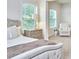 Bright bedroom features a tufted bed, side tables, and ample natural light at 112 Filigree Way, Durham, NC 27713