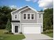 Charming two-story home with gray siding, white trim, black door, and two-car garage at 1172 Solace Way, Rolesville, NC 27571