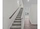 Bright hallway featuring a carpeted staircase with wood railing and durable wood-look floors at 1201 Solace Way, Rolesville, NC 27571