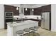 Well-equipped kitchen with stainless steel appliances, center island with seating, and dark wood cabinetry at 1205 Masters Place Way # 183, Durham, NC 27703