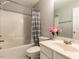 Bright bathroom featuring a shower-tub combo, neutral colors, and vanity with flowers at 122 Button Rd, Morrisville, NC 27560