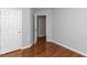 Bedroom with hardwood floors, neutral gray walls, and a closet door at 122 Button Rd, Morrisville, NC 27560