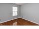 Clean, simple bedroom with hardwood floors and a window at 122 Button Rd, Morrisville, NC 27560