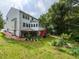 Rear exterior view of a two-story home featuring a large backyard with landscaping, covered patio, and deck at 122 Button Rd, Morrisville, NC 27560