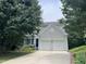 Charming two-story home featuring a two-car garage and well-maintained front yard, framed by mature trees at 122 Button Rd, Morrisville, NC 27560