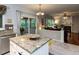 Open kitchen with granite island and views into a sunroom and living area with fireplace at 122 Button Rd, Morrisville, NC 27560
