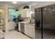 Kitchen features stainless appliances, marble-look floors, white cabinets, a double sink and a light filled window at 122 Button Rd, Morrisville, NC 27560