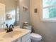 Cozy half bathroom with a decorative mirror, a vanity, and natural light from a window at 122 Button Rd, Morrisville, NC 27560