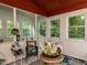 Enclosed sunroom with multiple windows providing abundant natural light and views of the surrounding trees at 122 Button Rd, Morrisville, NC 27560