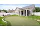 Backyard featuring a putting green, firepit, and screened in back porch at 13 Nettletree Creek Ct, Youngsville, NC 27596