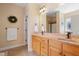 Bathroom featuring a double sink vanity with granite countertops, wood cabinets, and large framed mirror at 13 Nettletree Creek Ct, Youngsville, NC 27596