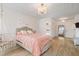 Elegant bedroom featuring chandelier, ample natural light, hanging swing chair, and light peach walls at 13 Nettletree Creek Ct, Youngsville, NC 27596