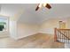 Bright bonus room with sloped ceilings, wood floors, ceiling fan and natural light from the window at 13 Nettletree Creek Ct, Youngsville, NC 27596