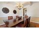 Traditional dining room featuring coffered ceilings, wood table with seating for six, decorative wall art, and view to kitchen at 13 Nettletree Creek Ct, Youngsville, NC 27596