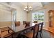 This dining room is illuminated by a chandelier, and features a table with seating for six and sunlit view at 13 Nettletree Creek Ct, Youngsville, NC 27596