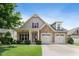Charming home showcasing manicured lawn, stone accents, a two-car garage, and red shutter details against a blue sky at 13 Nettletree Creek Ct, Youngsville, NC 27596