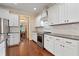Modern kitchen featuring stainless steel appliances, white cabinetry, marble backsplash, dark countertops, and hardwood flooring at 13 Nettletree Creek Ct, Youngsville, NC 27596