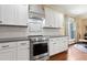 Well-appointed kitchen featuring white cabinets, granite countertops, stainless steel appliances, and stylish backsplash at 13 Nettletree Creek Ct, Youngsville, NC 27596