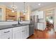 Bright and airy kitchen featuring stone accent wall, stainless steel appliances, white cabinets, and hardwood floors at 13 Nettletree Creek Ct, Youngsville, NC 27596