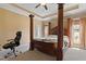 Serene main bedroom featuring a canopy bed, hardwood-style accent wall, tray ceiling, and soft natural light at 13 Nettletree Creek Ct, Youngsville, NC 27596