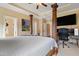 Spacious bedroom with a four poster bed, ceiling fan, and a wall-mounted television over a workspace at 13 Nettletree Creek Ct, Youngsville, NC 27596