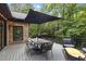 Well-designed outdoor deck with dining area and modern black umbrella offering backyard view at 13121 Melvin Arnold Rd, Raleigh, NC 27613