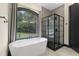 Luxurious bathroom with freestanding tub, glass-enclosed shower, and elegant finishes at 13121 Melvin Arnold Rd, Raleigh, NC 27613