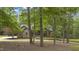 Brick home nestled among trees with an inviting driveway, offering a sense of privacy and natural beauty at 13121 Melvin Arnold Rd, Raleigh, NC 27613