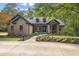 Inviting brick home with mature trees and landscaped front yard, showcasing a well-maintained exterior at 13121 Melvin Arnold Rd, Raleigh, NC 27613