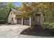 Spacious two-car garage with a brick facade, complemented by lush landscaping and a well-maintained driveway at 13121 Melvin Arnold Rd, Raleigh, NC 27613