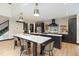Open kitchen with large island, modern appliances, and stylish lighting fixtures at 13121 Melvin Arnold Rd, Raleigh, NC 27613