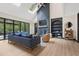Bright living room with a fireplace, skylight, and large windows offering natural light and outdoor views at 13121 Melvin Arnold Rd, Raleigh, NC 27613