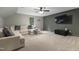 Cozy living room featuring a comfortable sectional sofa, ceiling fan, and a wall-mounted TV at 13121 Melvin Arnold Rd, Raleigh, NC 27613