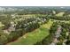An aerial view shows a golf course community featuring houses, a golf course, and a lake at 1420 Heritage Links Dr, Wake Forest, NC 27587
