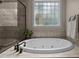 Relax in the garden tub nestled by a decorative window in this luxurious bathroom at 1420 Heritage Links Dr, Wake Forest, NC 27587