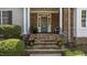Inviting front porch featuring stone stairs, wrought iron railings, and decorative potted plants at 1420 Heritage Links Dr, Wake Forest, NC 27587