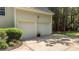 Two-car garage nestled beside mature trees with a tidy garden and curb appeal at 1420 Heritage Links Dr, Wake Forest, NC 27587