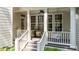 Charming porch with white columns, a ceiling fan, and a swing, offering a relaxing outdoor space at 1420 Heritage Links Dr, Wake Forest, NC 27587