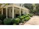 Covered back porch features ceiling fans and comfortable seating surrounded by manicured landscaping at 1420 Heritage Links Dr, Wake Forest, NC 27587