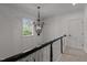 Elegant staircase with a decorative chandelier and natural light from the window at 1420 Heritage Links Dr, Wake Forest, NC 27587